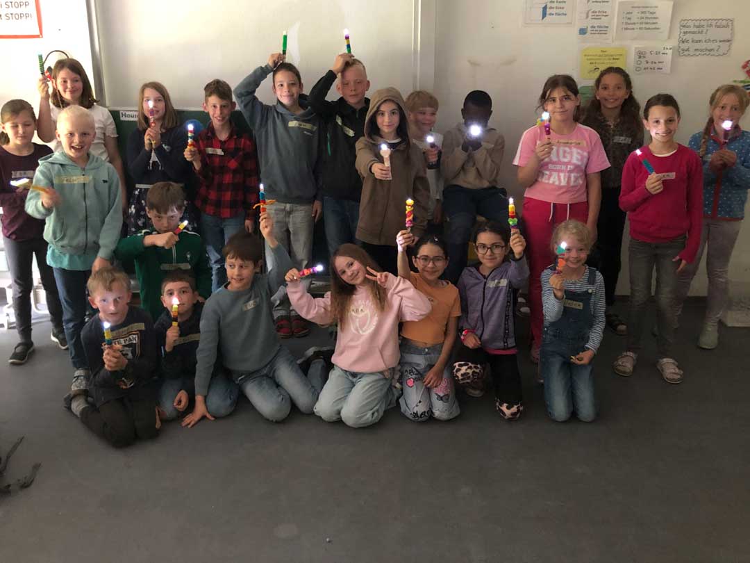 ZAK1 Kinder Zeigen ihre selbstgebauten Taschenlampen.